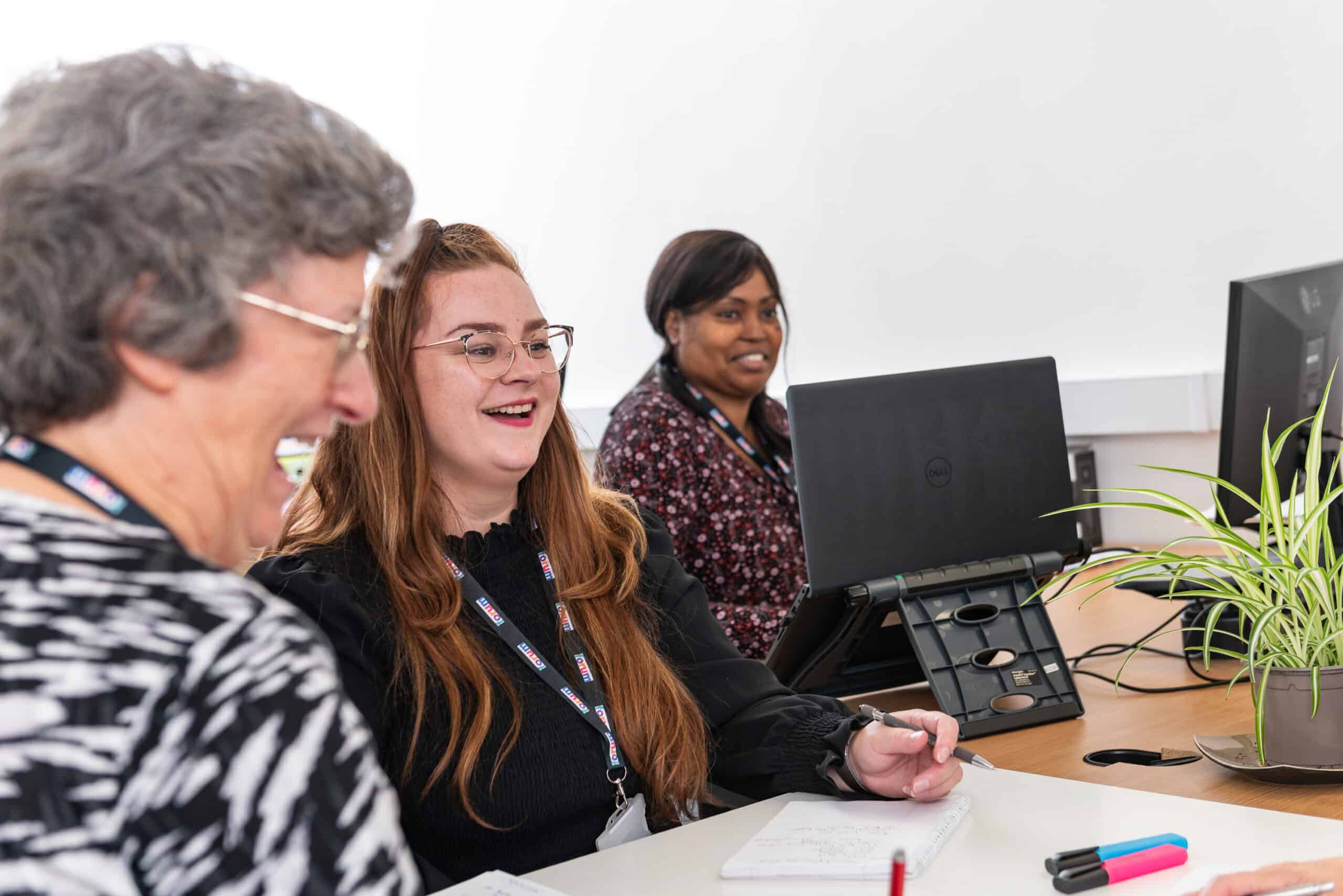 Forum Advice and Consultancy, two female team members going over papers at their desks